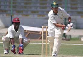 Pakistan women's cricket team member Kiran Baluch plays a delivery to reach her century as West Indies wicketkeeper Stephanie Power looks on 