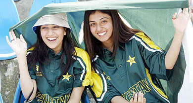 Pakistani girls wearing cricket team kit hold their national flag during the Pakistan-India second one-dayer