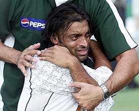 Pakistani physio assists speedster Shoaib Akhtar to warm-up during a training session in Lahore