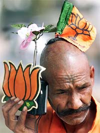 A BJP supporter listens to radio as he sports the party�s symbol and flag at Chandigarh