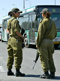 Israeli women soldiers check a bus at a temporary checkpoint in Jerusalem on Tuesday. 
