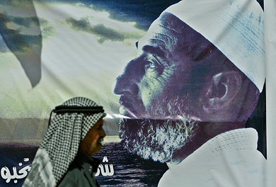 A man walks by a poster of late Hamas founder Sheikh Ahmed Yassin in Gaza City