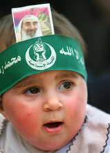 A child wears a Hamas headband with a picture of Hamas founder Sheikh Ahmed Yassin sttached to it at a Hamas mourning house in Gaza City 