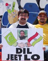 A cricket fan holds a placard depicting friendship between India and Pakistan 