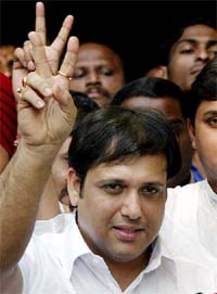 Bollywood star Govinda flashes a victory sign during a news conference in Mumbai