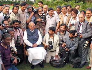 Prime Minister Atal Bihari Vajpayee poses with news photographers at his residence in New Delhi 
