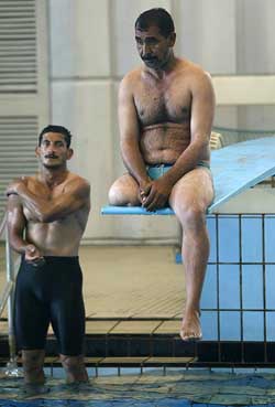A competitor rests on a diving board before the start of Iraq's first Handicapped Swimming championships 