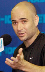 Andre Agassi gestures as he talks to reporters