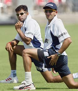 Ajit Agarkar and Akash Chopra perform stretching exercises during a training session in Multan