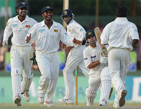Australia's captain Ricky Ponting looks up as Sri Lankan team members celebrate his dismissal