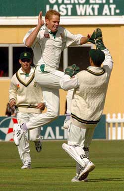 Shaun Pollock, left, high fives keeper Mark Boucher after bowling Chris Cairns