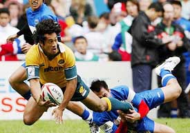 Australia's Chris Siale is airborne as he is tackled by Taiwan's Wu Chih-Hsien during their Hong Kong Sevens rugby match