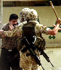 British soldiers, part of a snatch squad, move in to detain an Iraqi man during a violent protest in the southern Iraqi city of Basra 