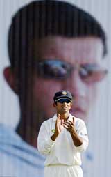 India's stand-in skipper Rahul Dravid applauds in front of a portrait of Saurav Ganguly