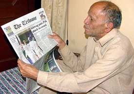 Virender Sehwag's father Krishan is engrossed with a copy of The Tribune