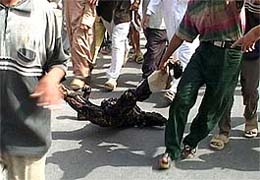 Iraqis drag the body of a man after an attack in Falluja