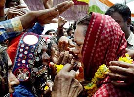 Banjara tribal women bless and touch the face of Congress President Sonia Gandhi during an election rally on the outskirts of Solapur, 500 km southeast of Mumbai