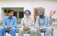 Labh Singh, who has tended Tohra�s fields for 50 years, sits in front of the house, which G.S. Tohra built for his family, along with his sons at Tohra village.