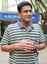 Indian cricketer Anil Kumble smiles as he stands outside a private nursing home