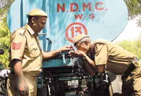 Delhi Police jawans drinking water from a tanker of the NDMC in the Capital on Saturday.