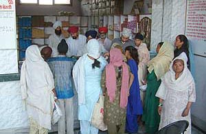 Widows receive ration from Mata Kaulan Bhalai Kendra on the Tarn Taran road in Amritsar on Sunday. 