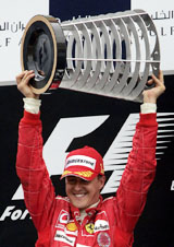 Ferrari's German F-1 world champion Michael Schumacher lifts the winner's trophy following his victory at the inaugural Bahrain Grand Prix 