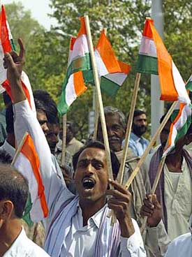 A supporter of the Congress chants slogans as he holds party flags during an election rally in Lucknow