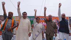 Sushma Swaraj waves to BJP supporters during a campaign rally in Kangra on Monday