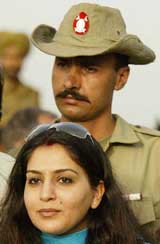 �Ajit Agarkar's wife Fatima Agarkar poses for a photograph as a Pakistani soldier stands guard 