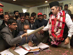 Omar Abdullah, president of the National Conference, hands his nomination papers to an official in Budgam, 15 km west of Srinagar, on Tuesday. 