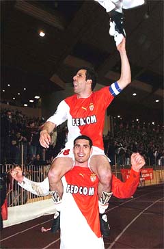 French soccer club AS Monaco's skipper Ludovic Giuly rides on the shoulders of teammate Julien Rodriguez 