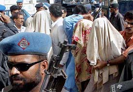 Pakistani policemen escort detained suspected Islamic militants with their faces covered outside an anti-terrorism court in Karachi 
