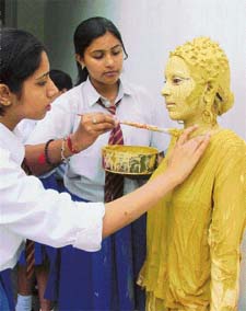 A participant of the inter-house fancy-dress competition gets last-minute touches from friends as she gets ready to act like a statue