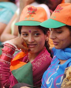 A newly married woman says something to a friend at the BJP election rally in Solan 