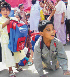 An eight-year-old physically challenged boy excited after getting a bag full of books and stationery at a function organised by Gyan Sthal Mandir