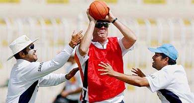 Virender Sehwag and Sachin Tendulkar play with coach John Wright during a training session in Rawalpindi 