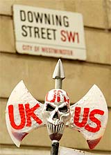 A demonstrator holds a bloodied axe with an anti-war slogan during a protest in front of Downing Street in London 