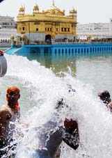Sikh devotees bathe in the filtered water that is being filled in the Amrit Sarovar of the Golden Temple