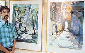 Sudipta Das Majumdar stands in the company of his water colours on display