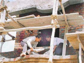 Neighbours lift the body of Ramu, who died along with a fellow mason after a portion of the roof of a house collapsed at Sunny Enclave in Bhabhat village, near Zirakpur