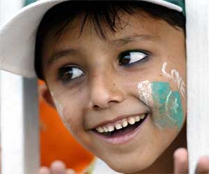 A Pakistani child with a national flag painted on his face watches the first day of the third Test match between Pakistan and India in Rawalpindi
