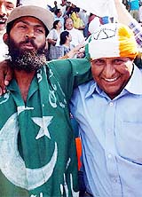 Cricket fans from India and Pakistan embrace each other as they watch the second day's proceedings 