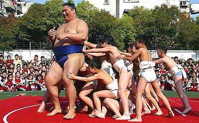 Japanese sumo wrestler Tamanoshima plays with Chinese schoolchildren 