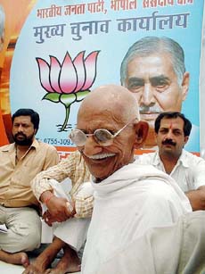 A supporter dressed as Mahatma Gandhi joins the BJP stage in Bhopal