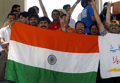 Indian cricket fans hold the Tricolour and cheer for their team 