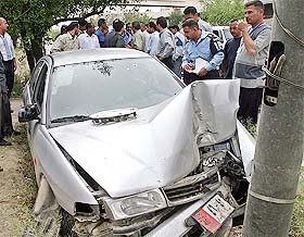 Iraqi police stand next to the wreckage of a vehicle in which an Iranian diplomat was shot near Iranian mission in Baghdad 