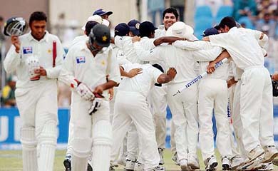 Indians celebrate their victory in the Test series as Danish Kaneria and Asim Kamal of Pakistan walk back to the pavilion at the Pindi Cricket Stadium