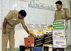HEADY CATCH: Delhi Police personnel showing the foreign liquor cartons seized from a godown in Paharganj area in the Capital on Saturday.