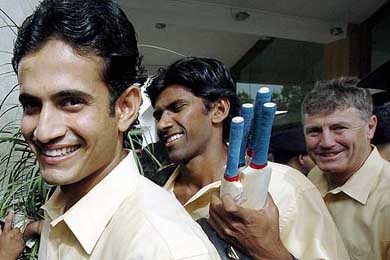 Indian cricketers Irfan Pathan and Laxmipathy Balaji  are followed by their coach John Wright as they prepare to board a bus to the airport