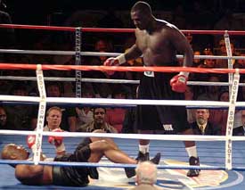 Hasim Rahman stands over Mario Cawley in the second round of a bout on Friday, in Dover, Del.